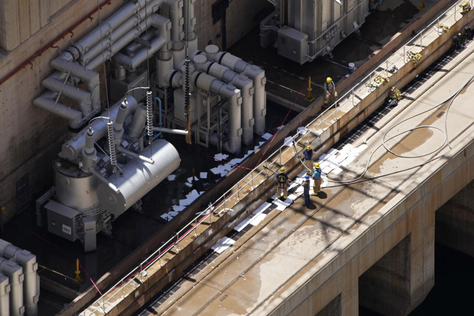 Firefighters work after a fire on the Arizona side of the Hoover Dam, Tuesday, July 19, 2022, near Boulder City, Nev. Officials say no one was injured when a transformer at Hoover Dam briefly caught fire Tuesday morning. (AP Photo/John Locher)