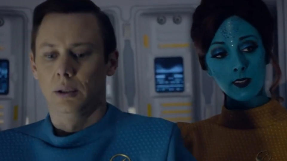 Jimmi Simpson standing next to a person in blue makeup in black Mirror