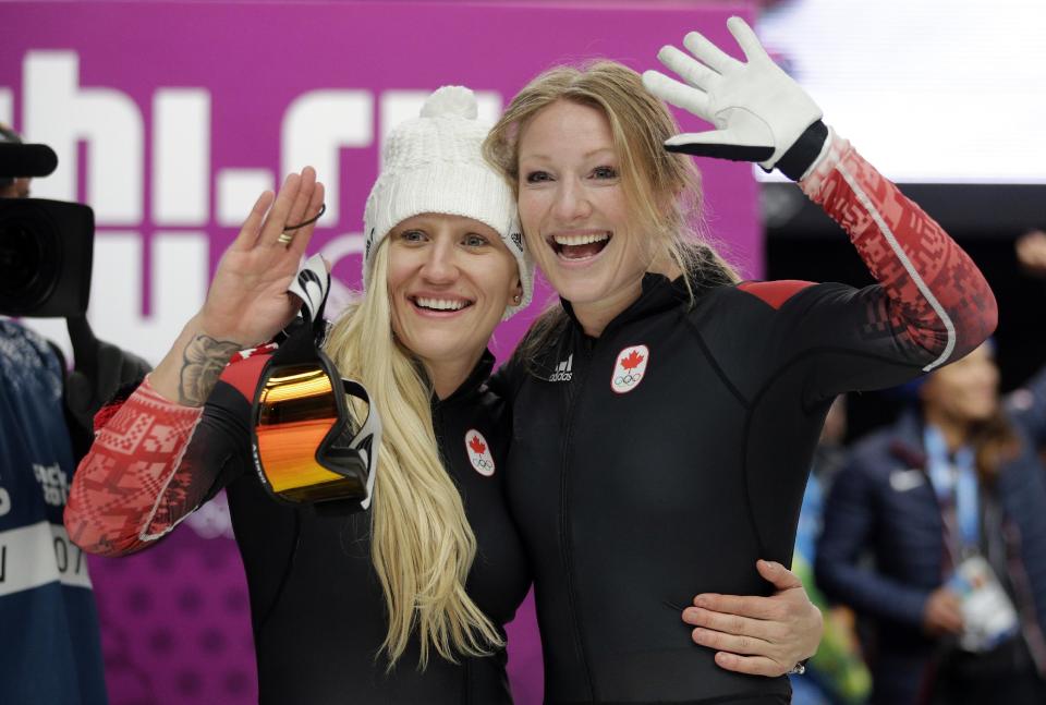 The team from Canada CAN-1, piloted Kaillie Humphries with brakeman Heather Moyse, wave to fans after their gold medal finish during the women's bobsled competition at the 2014 Winter Olympics, Wednesday, Feb. 19, 2014, in Krasnaya Polyana, Russia. (AP Photo/Jae C. Hong)