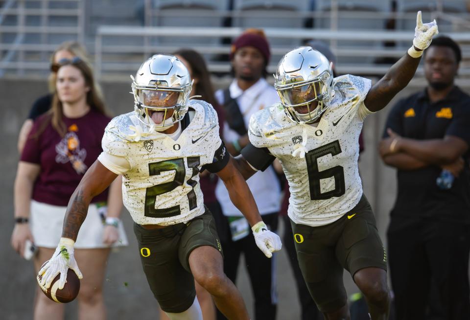 Oregon Ducks defensive back Cole Martin (21) celebrates an interception with teammate Jahlil Florence (6) against the Arizona State Sun Devils in the second half at Mountain America Stadium Nov. 18, 2023, in Tempe, Arizona.