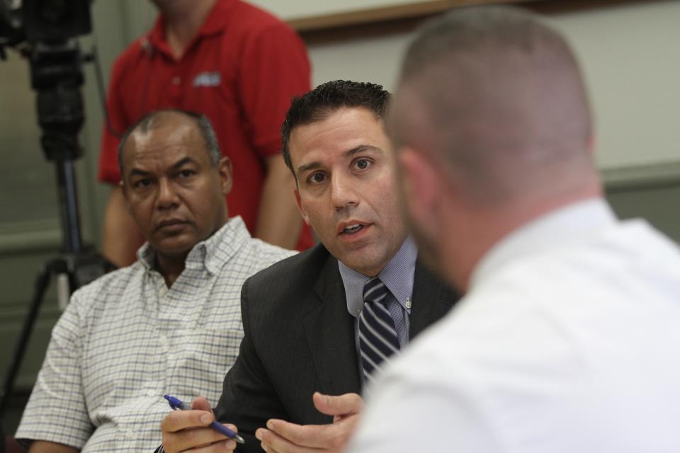 In a 2014 hearing of the Providence Board of Licenses, lawyer John Ciolli, center, representing a bar, questions a Providence police officer.