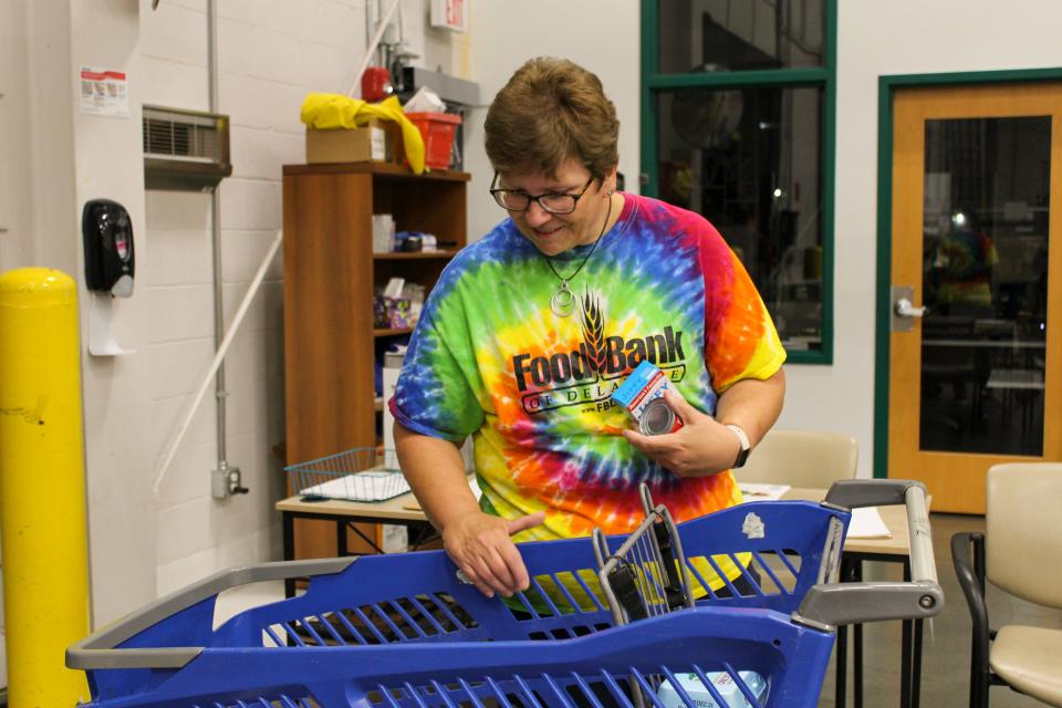 Jill Fredel, one of the Food Bank of Delaware's longest-standing volunteers, loads up a cart as a part of the organization's curbside pickup initiative.
