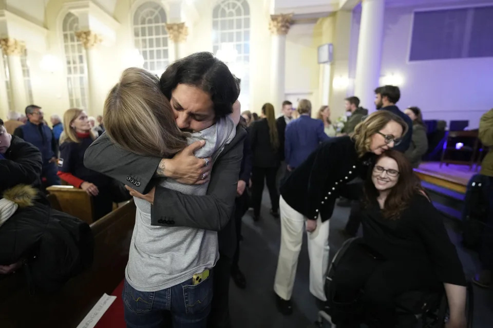 Tim Hernandez hugs Kallie Leyba as former Arizona Rep. Gabby Giffords, second from right, hugs Anne Marie Hochhalter, right during a vigil remembering the 25th anniversary of the Columbine High School mass shooting, Friday, April 19, 2024, in Denver. (AP Photo/Jack Dempsey)