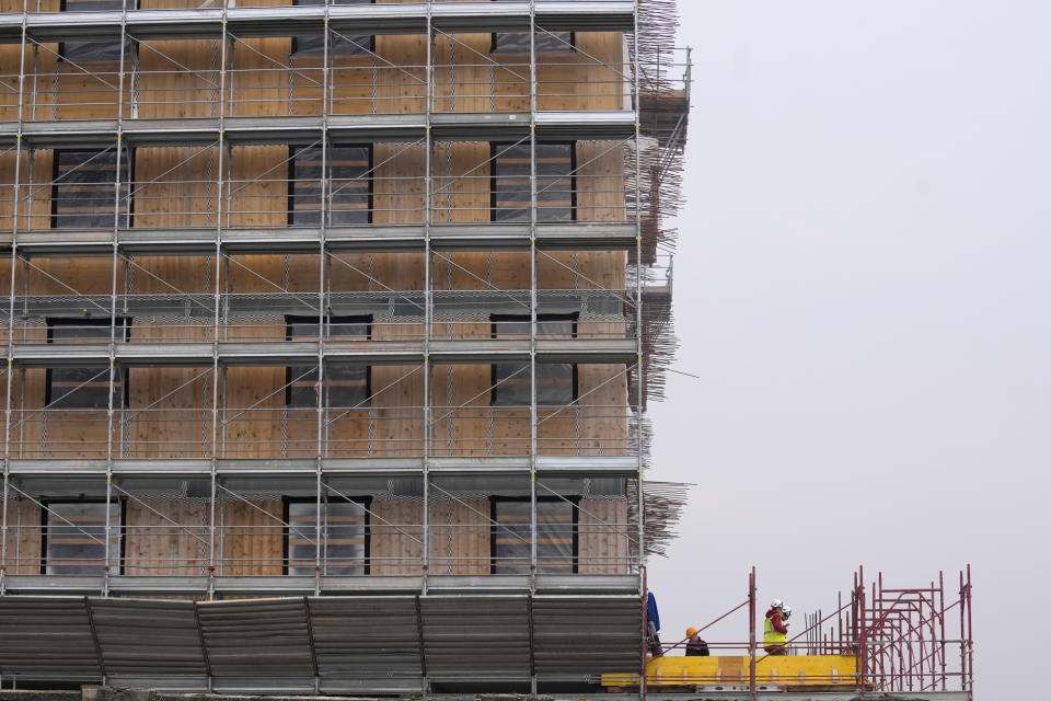 Workers build the Olympic Village at the Porta Romana former railway yard, in Milan, Italy, Tuesday, Feb. 6, 2024. The 2026 Milan-Cortina Olympics start exactly two years from Tuesday and it still seems like there are more questions than answers for a complicated games that will be staged across a large swath of northern Italy spread between five different venue clusters. (AP Photo/Antonio Calanni)