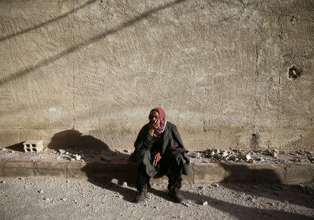 A man sits on a curb in Douma, Eastern Ghouta in Damascus, Syria January 22, 2018. REUTERS/Bassam Khabieh