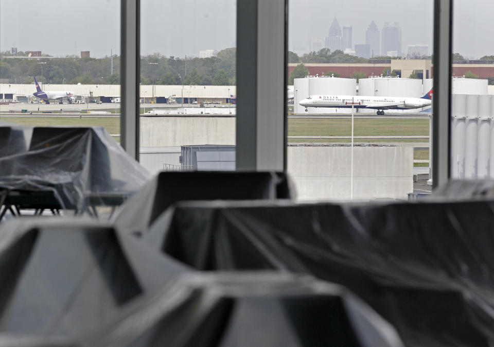 The Atlanta skyline is seen in the background as chairs sit covered in plastic in the new Maynard Holbrook Jackson Jr. International Terminal at Atlanta's airport Wednesday, March 28, 2012. The new $1.4 billion international terminal at the world's busiest airport will be a sleek launching pad for millions of passengers that’s designed to help Atlanta grab a growing share of the lucrative market for global travelers. (AP Photo/David Goldman)