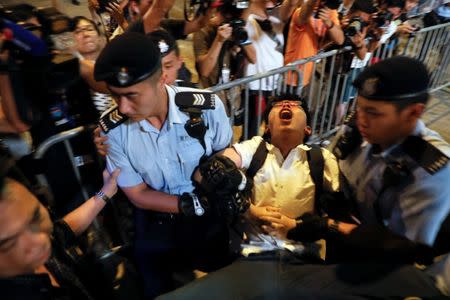 Student protest leader Joshua Wong shouts as he is carried by policemen as protesters are arrested at a monument symbolising the city's handover from British to Chinese rule, a day before Chinese President Xi Jinping is due to arrive for the celebrations, in Hong Kong, China June 28, 2017. REUTERS/Damir Sagolj