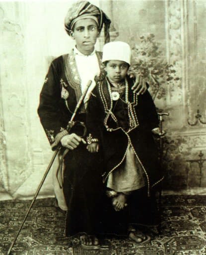 Qaboos is seen as a child sitting on his father's lap