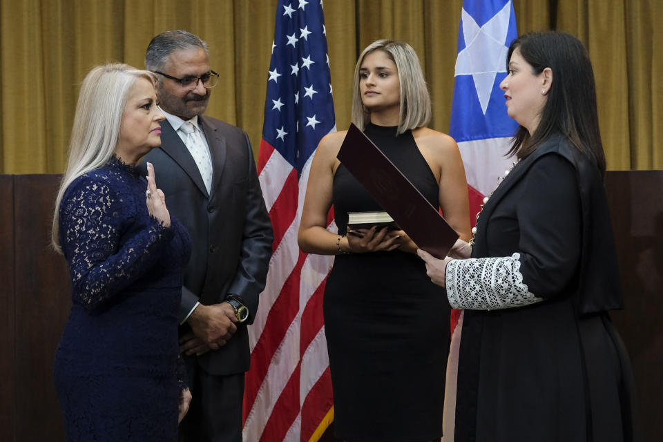 Justice Secretary Wanda Vazquez is sworn in as governor of Puerto Rico by Supreme Court Justice Maite Oronoz, in San Juan, Puerto Rico, Wednesday, Aug. 7, 2019. Vazquez took the oath of office early Wednesday evening at the Puerto Rican Supreme Court, which earlier in the day ruled that Pedro Pierluisi's swearing in last week was unconstitutional. Vazquez was joined by her daughter Beatriz Diaz Vazquez and her husband Judge Jorge Diaz. (AP Photo/Dennis M. Rivera Pichardo)