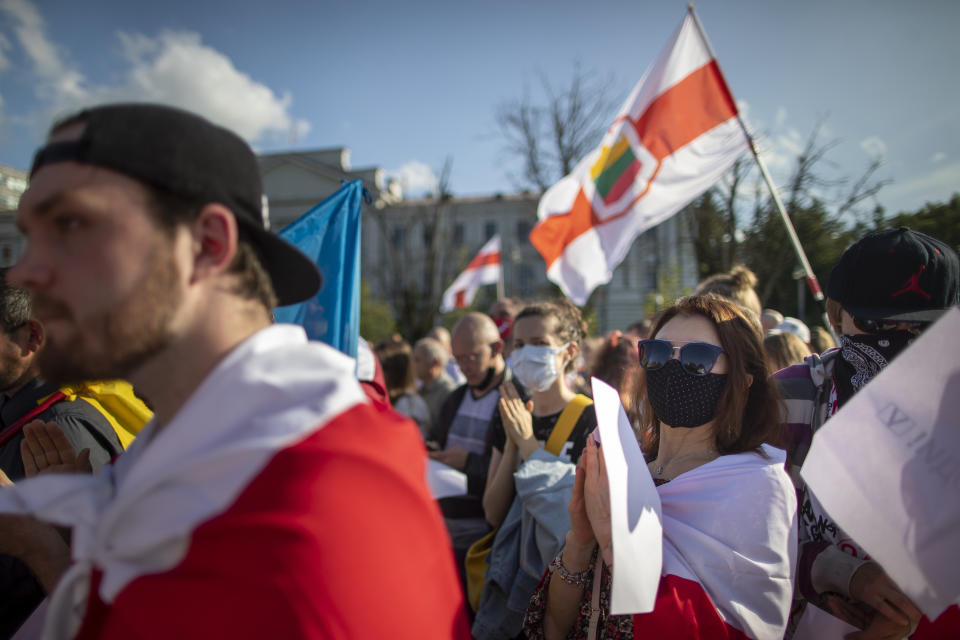 Belarusian people attend a demonstration marking one year since the protests in Belarus, at the Lukiskes square in Vilnius, Lithuania, Monday, Aug. 9, 2021. Belarus was shaken by months of protests triggered by Lukashenko re-election a year ago, the largest of which drew up to 200,000 people. Belarusian authorities responded to the protests with a relentless crackdown that saw more than 35,000 people arrested and thousands beaten by police. Leading opposition figures have been jailed or forced to leave the country. (AP Photo/Mindaugas Kulbis).