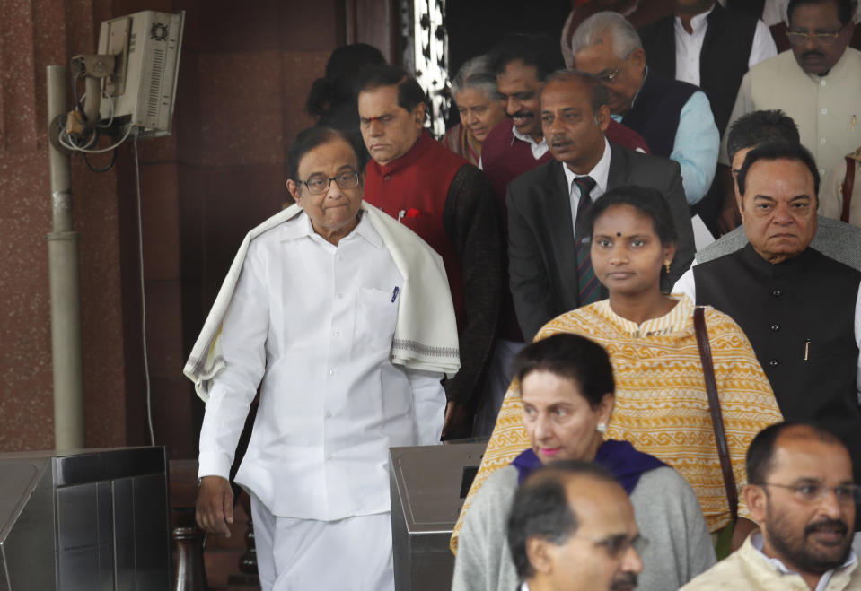 Indian lawmaker and former Finance Minister P. Chidambaram, left, comes out from the Parliament House to join a protest in New Delhi, India, Thursday, Dec. 5, 2019. Within hours of his release from prison on bail in a case involving alleged bribery and money laundering, Chidambaram joins his party's protest outside Parliament against the government's economic policies bringing down the country's economic growth to 4.5 percent, its slowest pace in six years. (AP Photo/Manish Swarup)