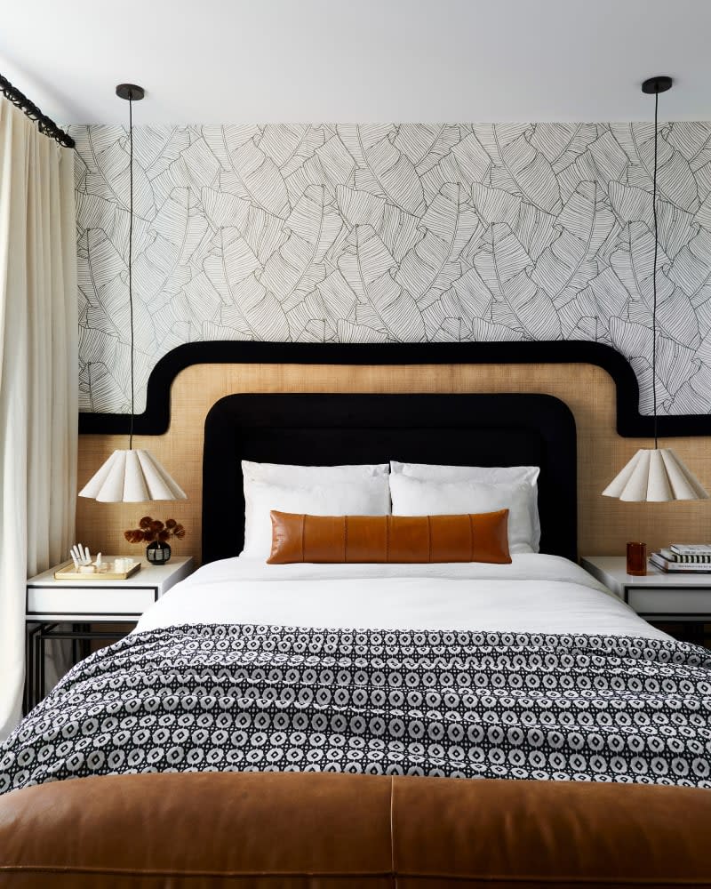 <span>The wallpaper is from Pottery Barn, the <a class="link " href="https://atmedia.link/product?url=https%3A%2F%2Fwww.brooklinen.com%2Fproducts%2Fluxe-duvet-cover%3Fvariant%3D7308908867" rel="nofollow noopener" target="_blank" data-ylk="slk:bedding is from Brooklinen;elm:context_link;itc:0;sec:content-canvas">bedding is from Brooklinen</a> and <a class="link " href="https://atmedia.link/product?url=https%3A%2F%2Fwww.target.com%2Fp%2Fmicroplush-bed-blanket-threshold-153%2F-%2FA-50950586" rel="nofollow noopener" target="_blank" data-ylk="slk:Target;elm:context_link;itc:0;sec:content-canvas">Target</a>, the <a class="link " href="https://atmedia.link/product?url=https%3A%2F%2Fwww.wayfair.com%2Fdecor-pillows%2Fpdp%2Fjustina-blakeney-tiger-pom-pom-hook-lumbar-pillow-ncxu1194.html" rel="nofollow noopener" target="_blank" data-ylk="slk:throw pillow is from Wayfair,;elm:context_link;itc:0;sec:content-canvas">throw pillow is from Wayfair,</a> and the <a class="link " href="https://atmedia.link/product?url=https%3A%2F%2Fwww.target.com%2Fp%2Fsmall-rattan-table-lamp-with-scallop-shade-beige--includes-led-light-bulb----opalhouse--8482--designed-with-jungalow--8482-%2F-%2FA-85331241" rel="nofollow noopener" target="_blank" data-ylk="slk:lampshades are from Target.;elm:context_link;itc:0;sec:content-canvas">lampshades are from Target.</a><br> Credit: <a href="https://www.veronicacrawfordphoto.com/" rel="nofollow noopener" target="_blank" data-ylk="slk:Veronica Crawford;elm:context_link;itc:0;sec:content-canvas" class="link ">Veronica Crawford</a></span> <span class="copyright">Credit: <a href="https://www.veronicacrawfordphoto.com/" rel="nofollow noopener" target="_blank" data-ylk="slk:Veronica Crawford;elm:context_link;itc:0;sec:content-canvas" class="link ">Veronica Crawford</a></span>