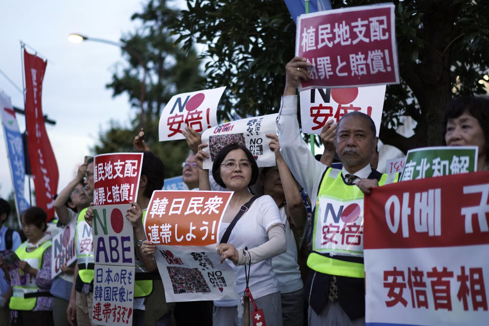 A group of protesters gather outside Japanese Prime Minister Shinzo Abe's residence in Tokyo Thursday, Aug. 8, 2019. They staged a rally with placards to urge the government to apologize for wartime atrocities in an effort fix rapidly souring relations. (AP Photo/Eugene Hoshiko)