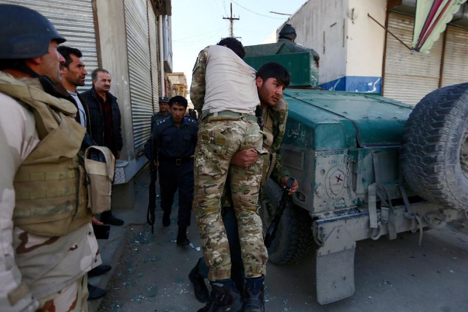 Afghan security forces help a comrade wounded in a suicide attack in Kabul, Afghanistan, Wednesday, March 1, 2017. A pair of suicide bombings, both claimed by the Taliban, struck the Afghan capital, an Afghan official said. (AP Photo/Rahmat Gul)