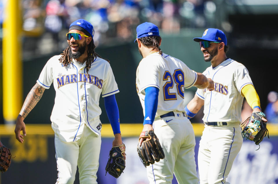 Seattle Mariners shortstop J.P. Crawford smiles with teammates third baseman Eugenio Suarez and second baseman Jose Caballero, right, as they celebrate their win over the Tampa Bay Rays after a baseball game, Sunday, July 2, 2023, in Seattle. (AP Photo/Lindsey Wasson)