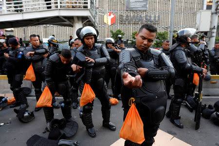 Riot police officers prepare as they guard during a protest across the Election Supervisory Agency (Bawaslu) headquarters following the announcement of the last month's presidential election results in Jakarta, Indonesia, May 22, 2019. REUTERS/Willy Kurniawan