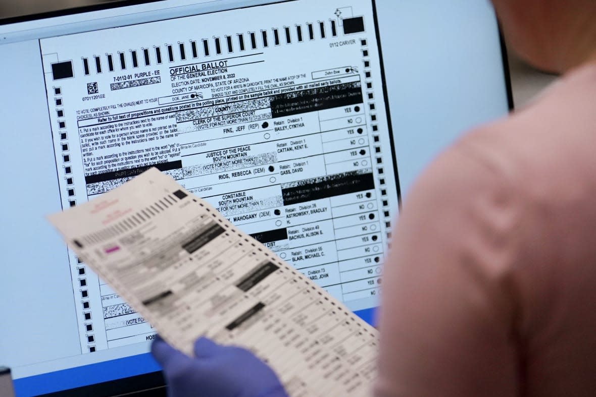 An election worker verifies a ballot on a screen inside the Maricopa County Recorders Office, Nov. 10, 2022, in Phoenix. Six Arizona counties will decide Monday, Nov. 28, whether to certify 2022 election results. (AP Photo/Matt York, File)