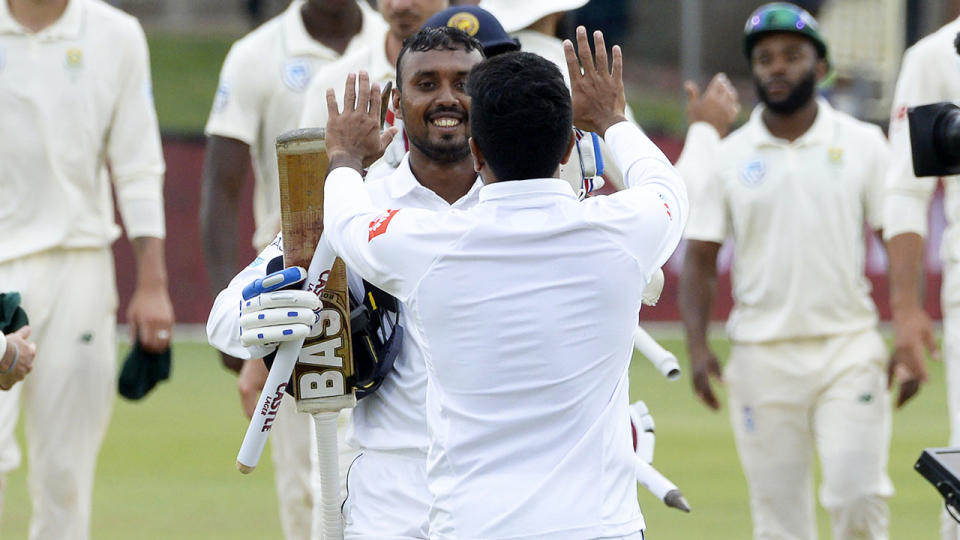 Oshada Fernando greets teammates after victory. (Photo by RODGER BOSCH/AFP/Getty Images)