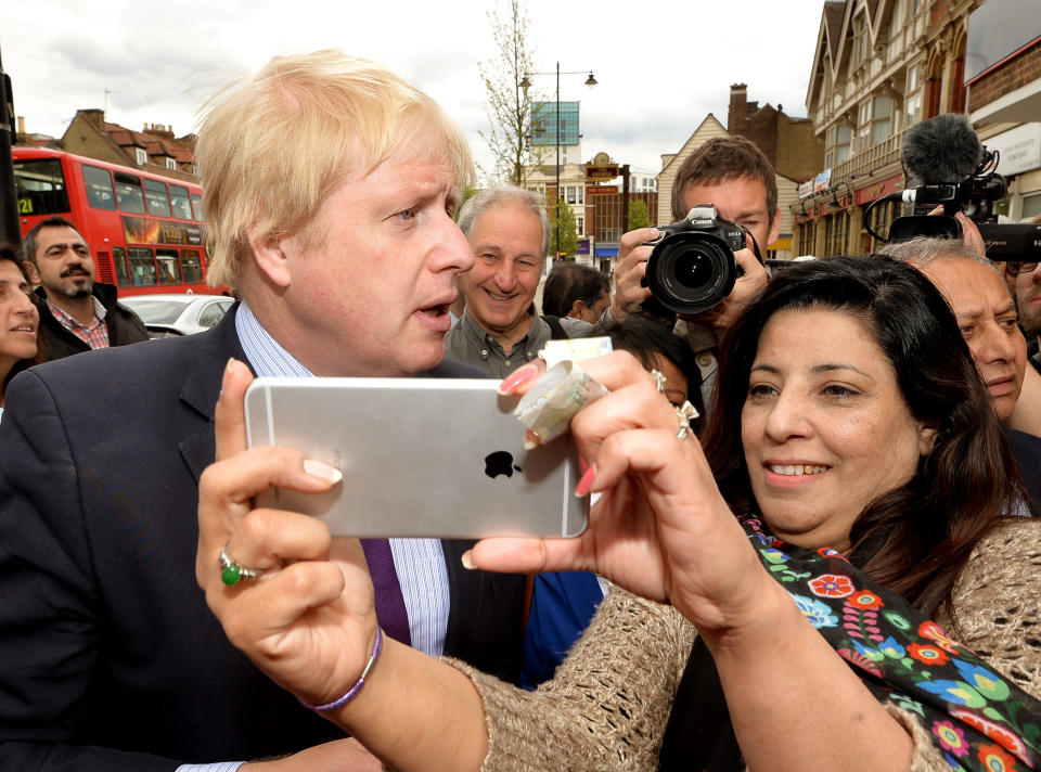A woman takes a selfie photo with Mayor of London Boris Johnson as he speak to residents in Enfield town centre while on the General Election campaign trail, as he gives his support to local Conservative candidate Nick De Bois (not in picture).