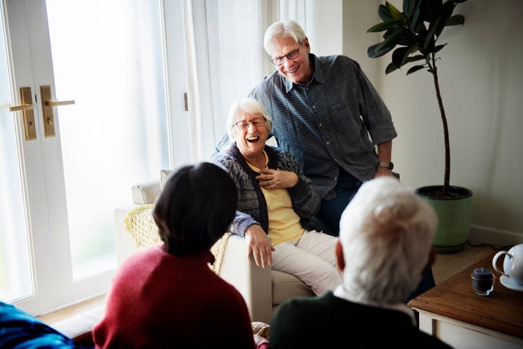 Four senior people socialising in a lounge room.