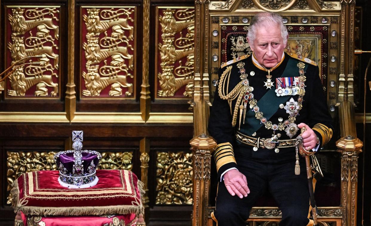 Prince Charles, Prince of Wales (R) sits by the The Imperial State Crown (L) in the House of Lords Chamber, during the State Opening of Parliament