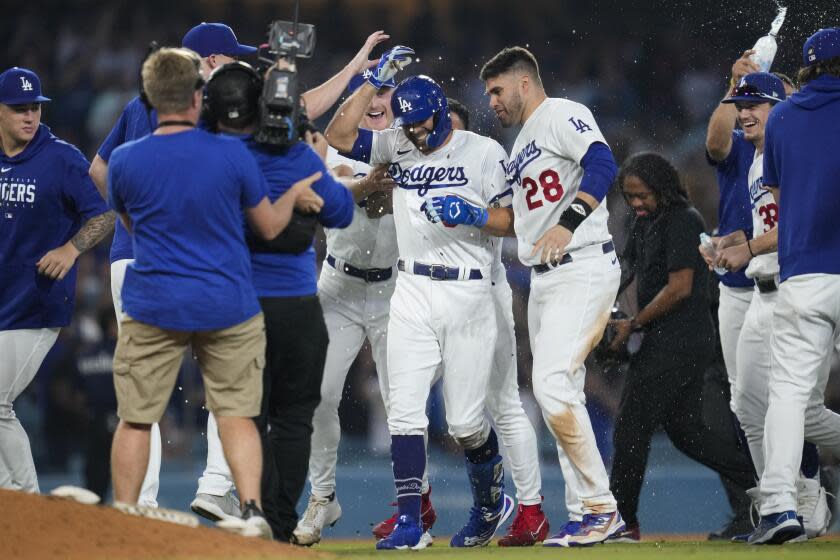 Los Angeles Dodgers' Chris Taylor, center, celebrates with teammates after hitting walk-off single to win a baseball game 3-2 against the San Francisco Giants in Los Angeles, Sunday, Sept. 24, 2023. Amed Rosario scored. (AP Photo/Ashley Landis)