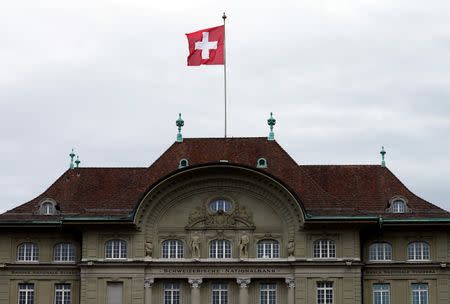 A Swiss national flag flutters in the wind atop the Swiss National Bank SNB headquarters in Bern, Switzerland April 16, 2015. REUTERS/Ruben Sprich/File Photo