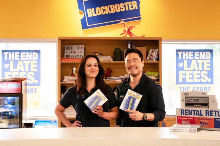 Melissa and Randall holding up Blockbuster movies