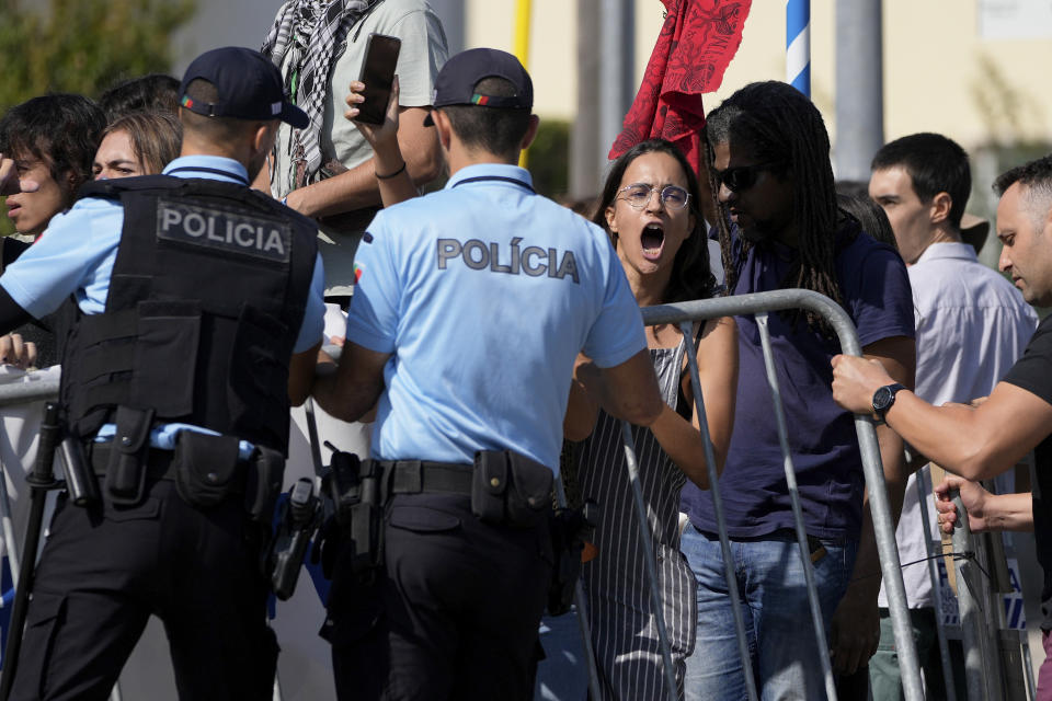 Police officers place barriers to contain climate activists protesting outside the Public Prosecutor's Office, in Oeiras, outside Lisbon, Friday, Sept. 15, 2023. Climate activists decided to cancel their Friday's for Future demonstration and instead stage a protest by the Public Prosecutor's Office in support of other activists detained the day before in a Stop Gas protest. (AP Photo/Armando Franca)