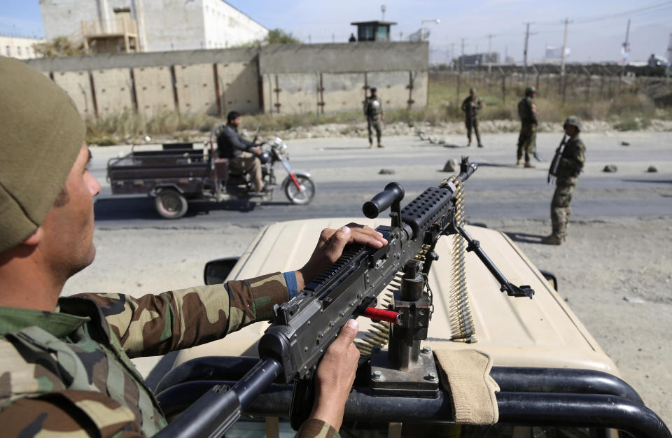 In this Wednesday, Oct. 17, 2018, photo, Afghan National Army soldiers stand guard at a checkpoint ahead of parliamentary elections, in Kabul, Afghanistan. Afghans will go to the polls on Saturday, hoping to bring change to a corrupt government that has lost nearly half the country to the Taliban. On Thursday, three top provincial officials in the southern province of Kandahar were killed by their own guards during a meeting to discuss security ahead of the vote. (AP Photo/Rahmat Gul)