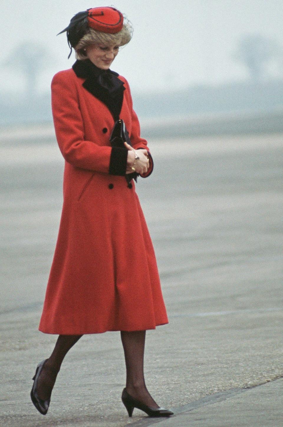 Diana, Princess of Wales wearing a red Catherine Walker coat upon her arrival to Birmingham airport in February 1984 (Jayne Fincher/Princess Diana Archiv)