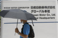 A man walks past Nissan Motor Co.'s global headquarters in Yokohama, near Tokyo, Tuesday, June 22, 2021. Nissan Chief Executive Makoto Uchida pleaded for patience from disgruntled shareholders Tuesday, promising a turnaround at the Japanese automaker, which is projecting a third year of losses as it struggles to distance itself from a scandal over its former Chairman Carlos Ghosn. (AP Photo/Koji Sasahara)