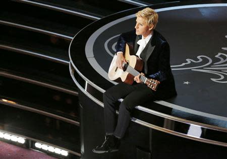 Host Ellen Degeneres plays a guitar at the 86th Academy Awards in Hollywood, California March 2, 2014. REUTERS/Lucy Nicholson