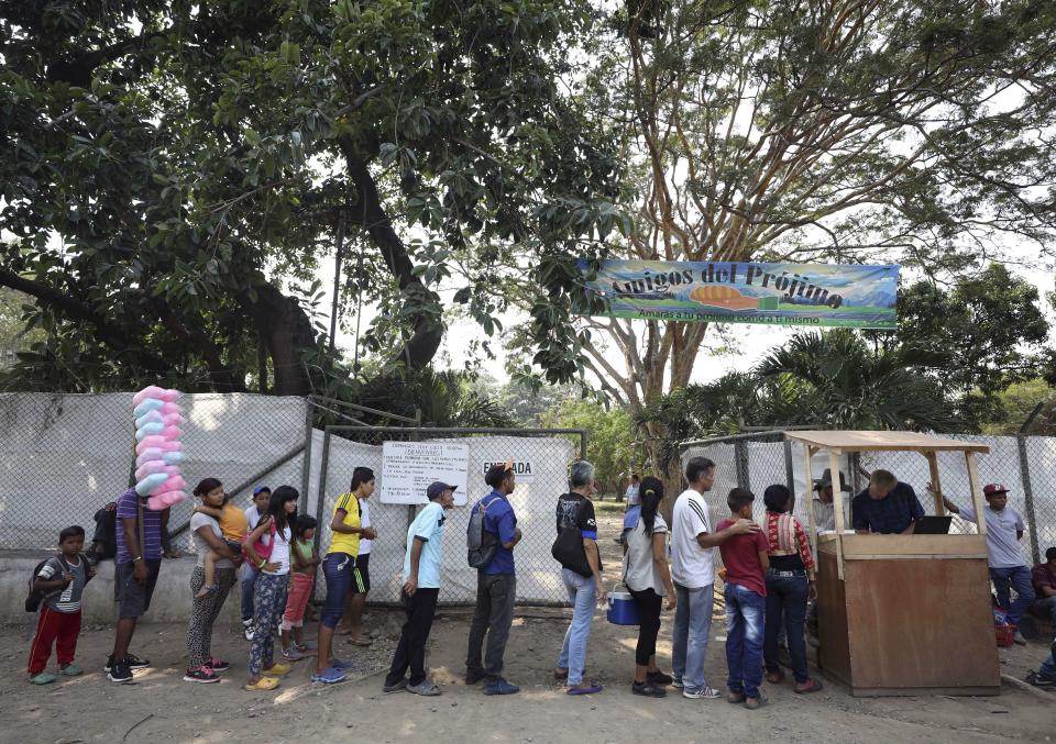 Venezuelan migrants stand in line for lunch at "Amigos Del Projimo" migrant shelter, in La Parada, on the outskirts of Cucuta, Colombia, on the border with Venezuela, Monday, Feb. 4, 2019. More than a dozen European Union countries endorsed Venezuelan opposition leader Juan Guaido as the county's interim president on Monday, piling the pressure on embattled President Nicolas Maduro to resign and clear the way for a new presidential election. (AP Photo/Fernando Vergara)