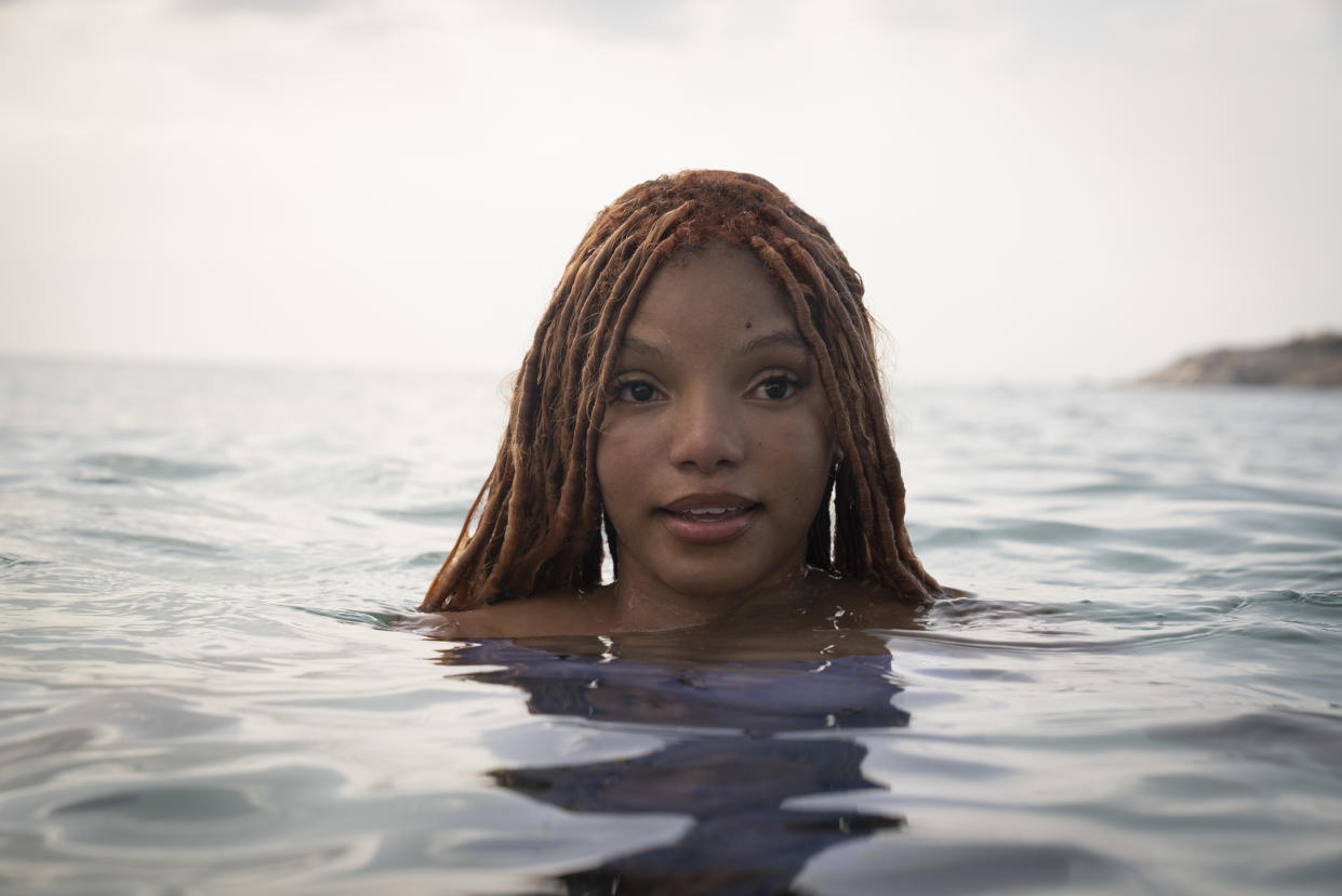 Halle Bailey swimming in the sea in a scene from in The Little Mermaid