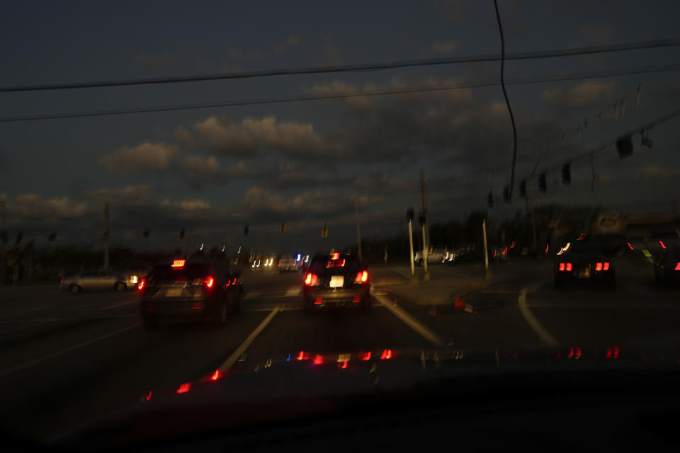 Cars navigate an intersection with no working traffic lights, a common sight as many areas remain without power three days after the passage of Hurricane Ian, in south Fort Myers, Fla., Saturday, Oct. 1, 2022. (AP Photo/Rebecca Blackwell)