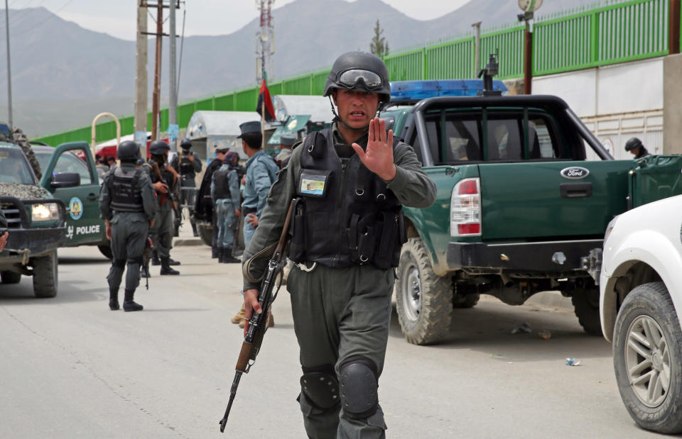 An Afghan policeman prevents journalists from approaching Cure International Hospital in Kabul, Afghanistan, Thursday, April 24, 2014. The U.S. embassy in Afghanistan says three American doctors have been killed at by an Afghan security guard who opened fire at a hospital in Kabul. The shooting at Cure International Hospital in western Kabul was the latest attack on foreign civilians in the Afghan capital this year. (AP Photo/Massoud Hossaini)