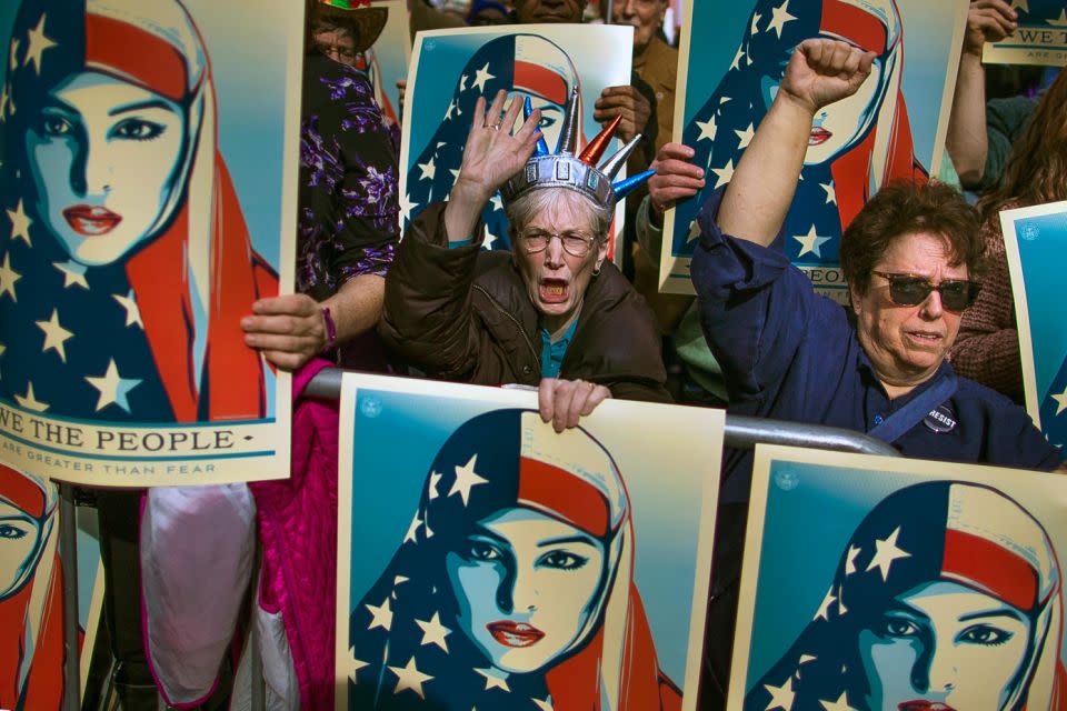 People carry posters during a rally in Times Square against Trump's order banning travel from seven Muslim-majority nations. Source: AP