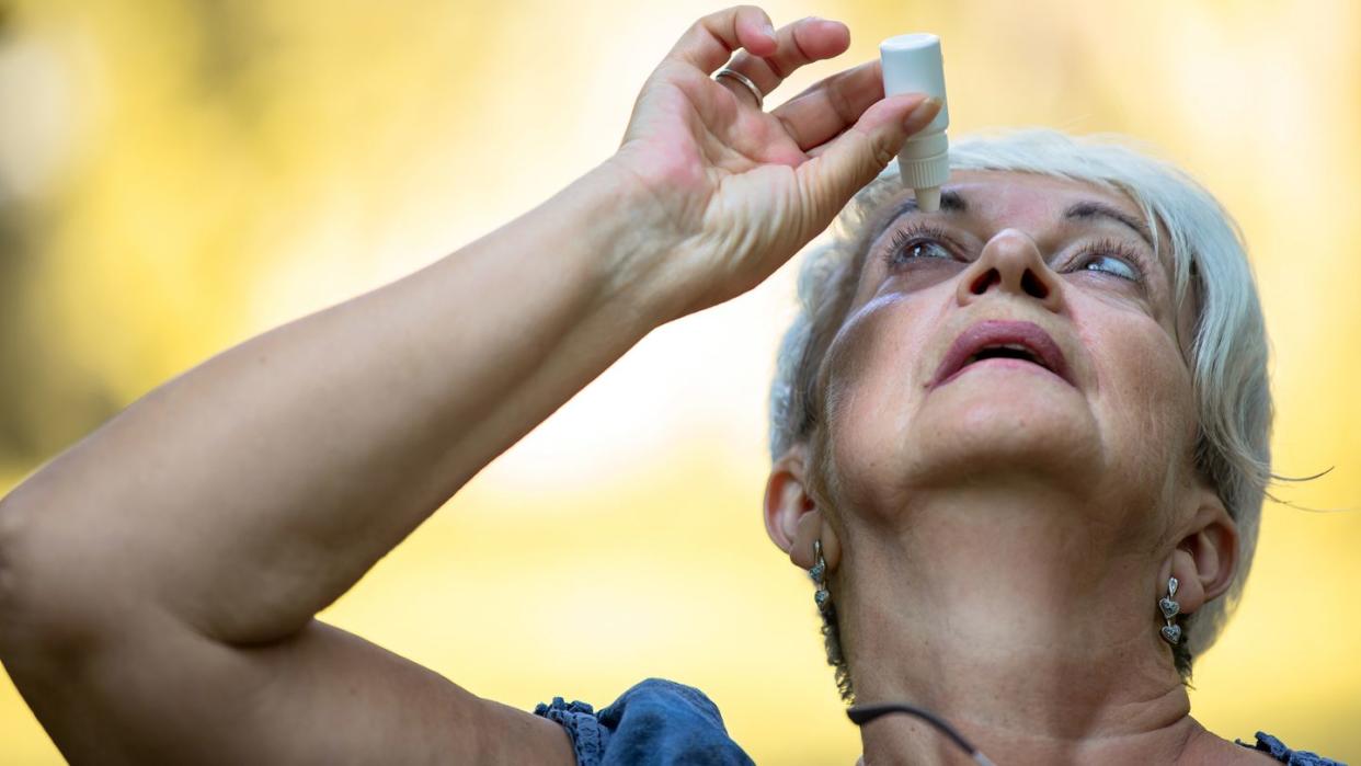 senior woman putting eye drop