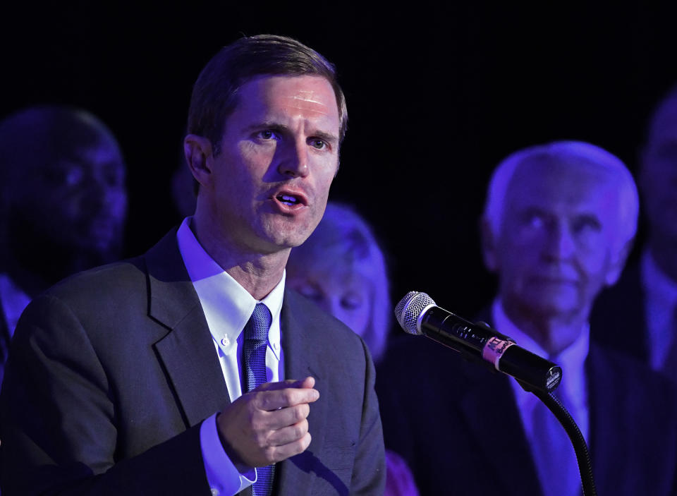 CORRECTS DATE TO TUESDAY, MAY 21 - Kentucky Attorney General Andy Beshear, left, addresses his supporters following his victory in the democratic primary for Governor in Louisville, Ky., Tuesday, May 21, 2019. Right is his father and former Kentucky Gov. Steve Beshear. (AP Photo/Timothy D. Easley)