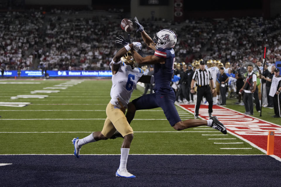 Arizona wide receiver Tetairoa McMillan (4) catches a touchdown pass in front of UCLA defensive back John Humphrey during the second half of an NCAA college football game Saturday, Nov. 4, 2023, in Tucson, Ariz. (AP Photo/Rick Scuteri)