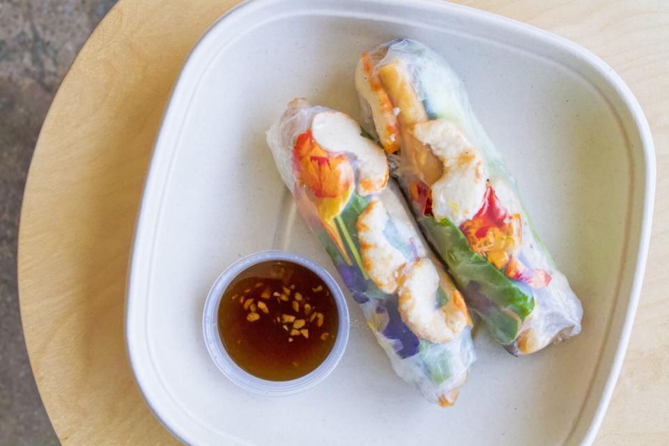 An overhead photo of two of Sesame Dinette's vegan-shrimp summer rolls with a side of tamarind dipping sauce.