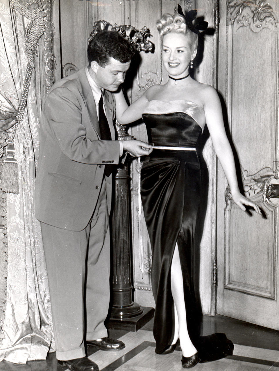 FILE - In this 1945 file photo, Associated Press reporter Bob Thomas measures the waist of legendary pinup queen Betty Grable. Thomas, the longtime Associated Press reporter who kept the world informed on the comings and goings of Hollywood's biggest stars, died of age-related illnesses Friday, March 14, 2014 at his Encino, Calif., home, his daughter Janet Thomas said. He was 92. (AP Photo/Courtesy Bob Thomas, File)