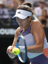 Spain's Garbine Muguruza makes a backhand return to Kiki Bertens of the Netherlands during their fourth round singles match at the Australian Open tennis championship in Melbourne, Australia, Monday, Jan. 27, 2020. (AP Photo/Andy Wong)