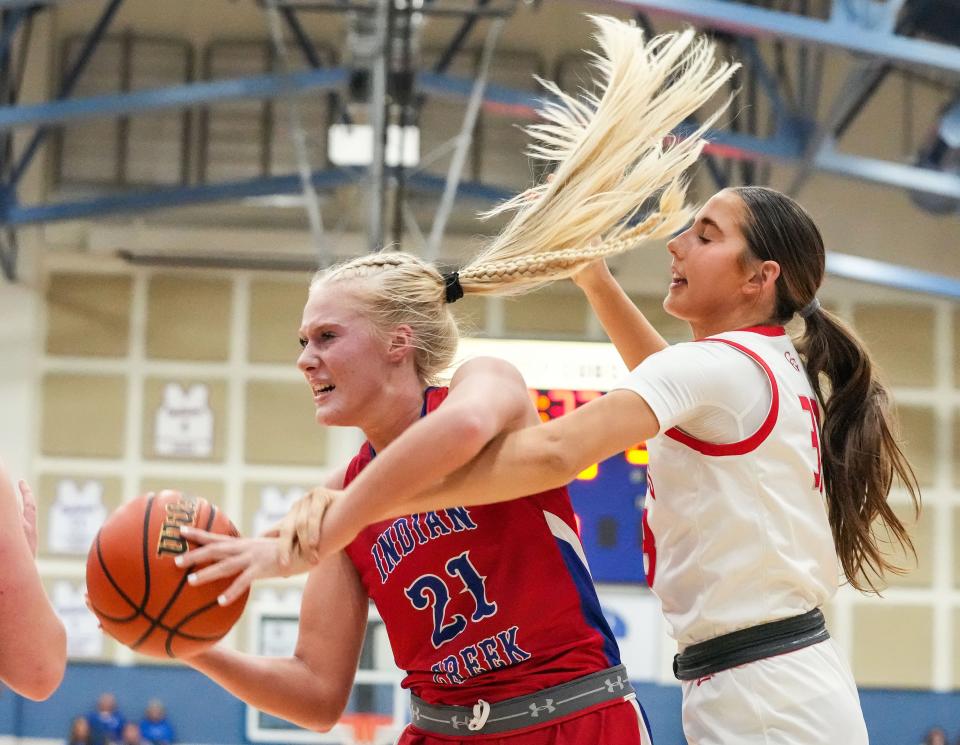 Indian Creek Faith Wiseman (21) recovers a rebound against Center Grove Trojans Rachel Wirts (33) on Thursday, Nov. 16, 2023, during the semifinals of the Johnson County Tournament at Franklin Community High School in Franklin. The Center Grove Trojans defeated Indian Creek, 61-52.