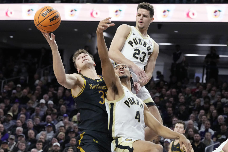 Northwestern forward Luke Hunger, left, battles for a rebound against Purdue forwards Camden Heide (23) and Trey Kaufman-Renn (4) during the first half of an NCAA college basketball game in Evanston, Ill., Friday, Dec. 1, 2023. (AP Photo/Nam Y. Huh)