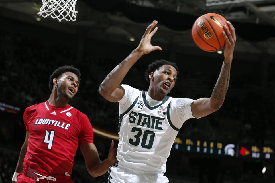 Michigan State's Marcus Bingham Jr., right, pulls down a rebound next to Louisville's Roosevelt Wheeler (4) during the first half of an NCAA college basketball game Wednesday, Dec. 1, 2021, in East Lansing, Mich. (AP Photo/Al Goldis)