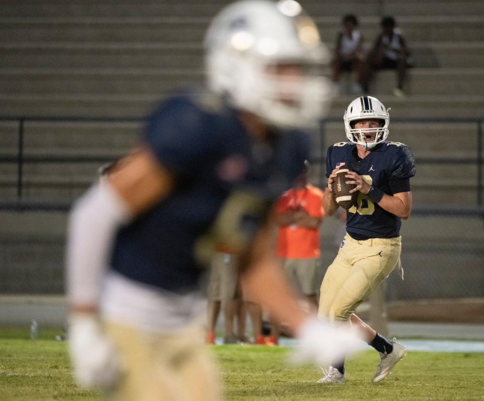Gulf Breeze quarterback Battle Alberson (No. 18) drops back to pass as he looks for an open receiver during Friday's game against Escambia.