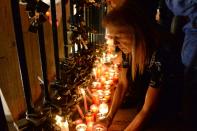 A woman lights a candle during a candlelight vigil in Sliema, on October 16, 2017, in tribute to late journalist Daphne Caruana Galizia who was killed by a car bomb close to her home in Bidnija, Malta