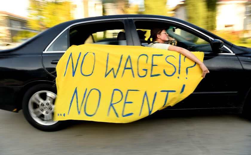 LOS ANGELES, CALIFORNIA MARCH 29, 2020-A protestors drives by the house of L.A. City Mayor Eric Garcetti in the Hancock Park area of Los Angeles Los Angeles Sunday. Tenant advocates are demanding a total and absolute moratorium on evictionsduring the coronavirus crisis. (Wally Skalij/Los Angeles Times)